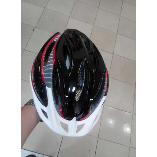 a person holding a helmet with a red stripe.