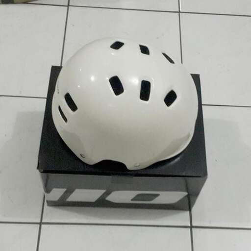 a helmet on a pedestal on a tile floor.