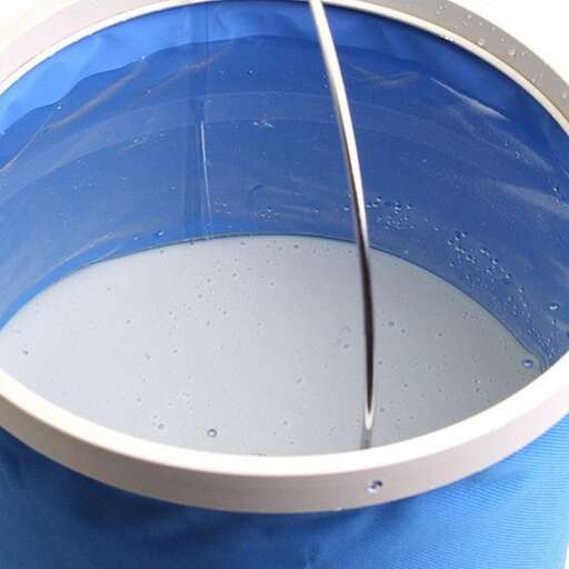 a bucket of milk being poured into a bucket.