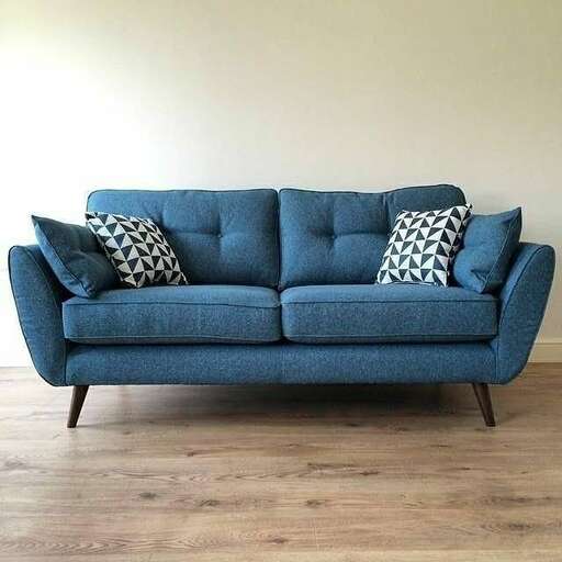 a blue couch sitting on top of a wooden floor.