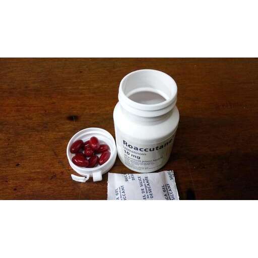 a jar of red berries on a table.