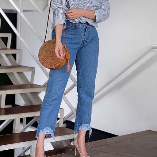 a model wearing a shirt, jeans and a bag.