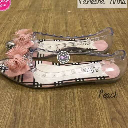 a pair of shoes with a pink flower on them.