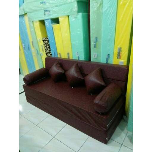 a couch with cushions on a tiled floor.