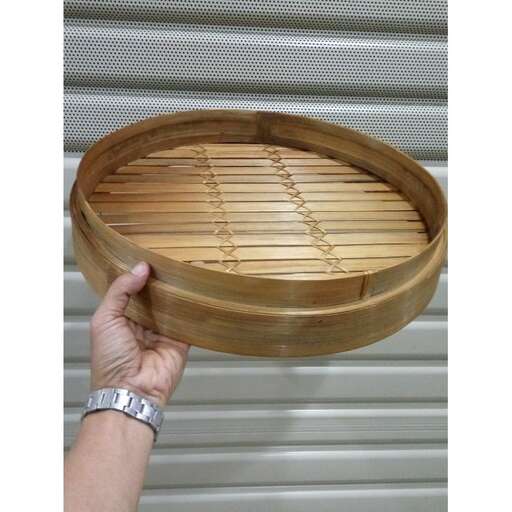 a hand holding a wooden bowl on a wall.