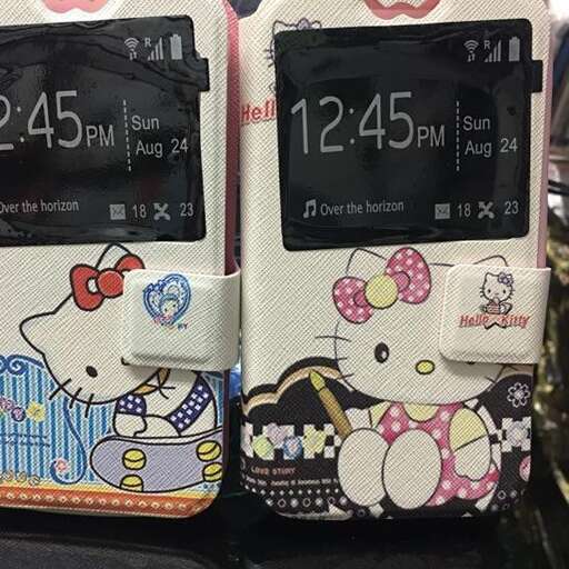 a couple of cell phones with hello kitty pictures on them.