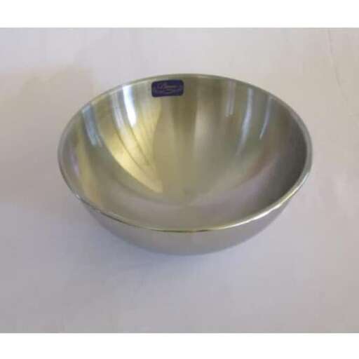 a silver bowl is sitting on a white surface.