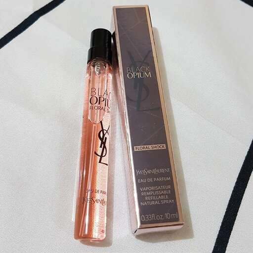 a bottle of perfume sitting on top of a white surface.