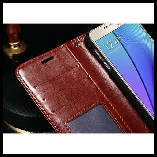 a cell phone is sitting next to a leather wallet.
