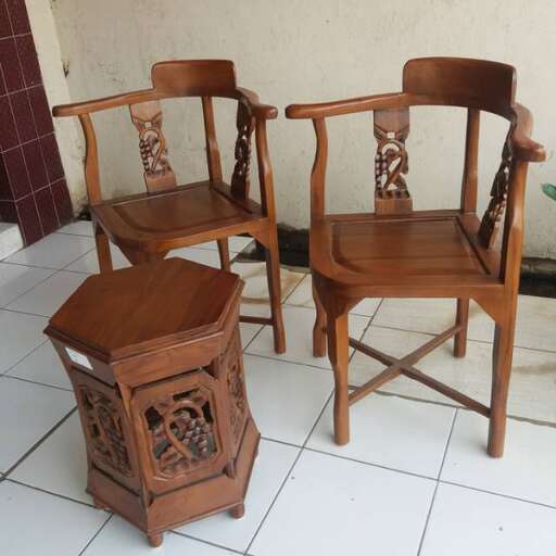 a pair of wooden chairs with a small table and a small stool.