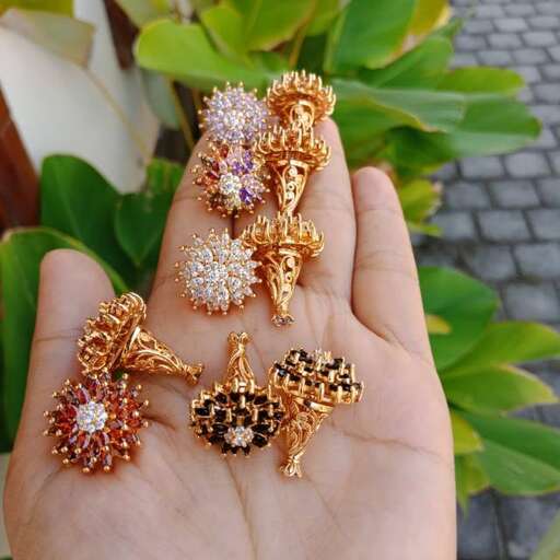 a hand holding a pair of earrings