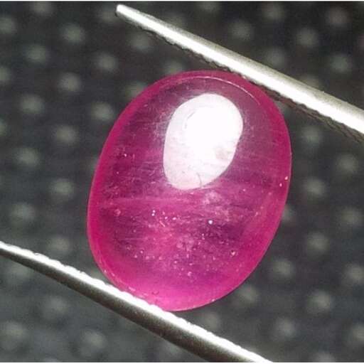 a pink glass ball in the shape of a sphere.