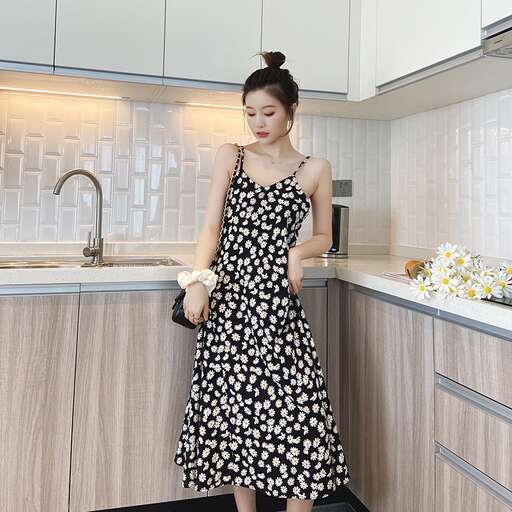 a woman in a black and white dress standing in a kitchen.