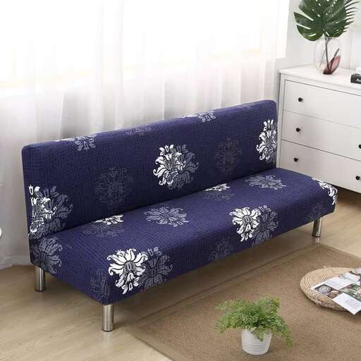 a couch with a plant on it sitting on a rug.