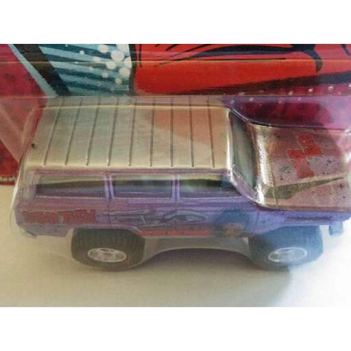 a toy car with a purple roof and a blue and red car in the background.