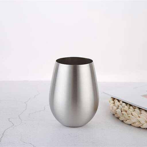 a silver vase is sitting on a table.