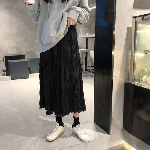 person in a black skirt and white sneakers