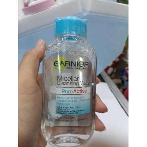 a bottle of mouthwash is shown in a hand.