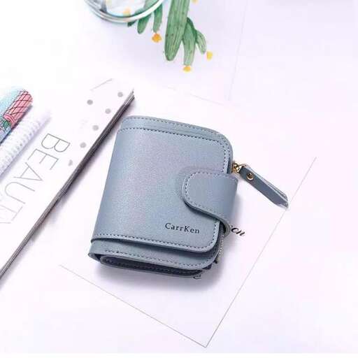a wallet with a zipper on it and a pen on the table.