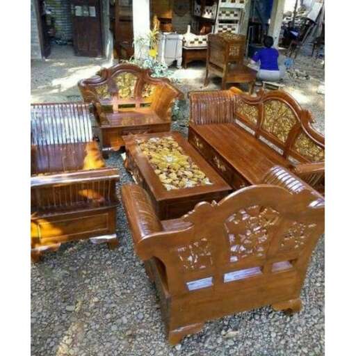 a group of wooden benches sitting on top of a gravel covered ground.