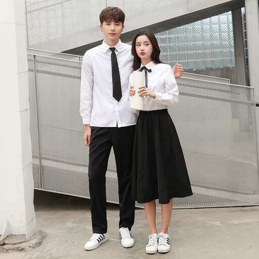 a young man and woman standing together in a courtyard.