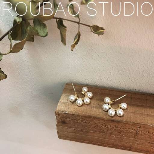 a wooden box with a pair of earrings on top of it.