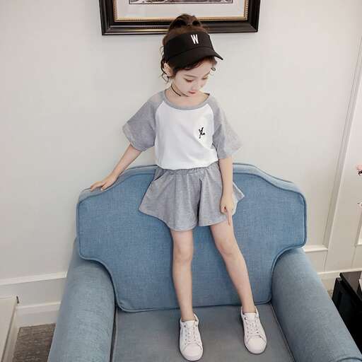 a little girl sitting on a blue couch.