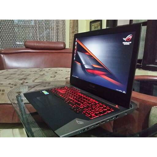 a laptop computer sitting on top of a glass table.
