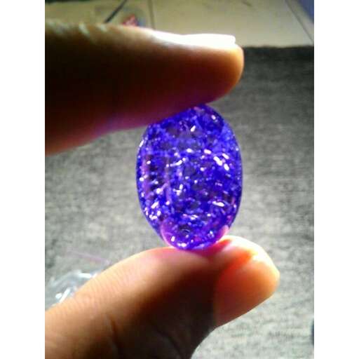 a purple sapphire in a hand