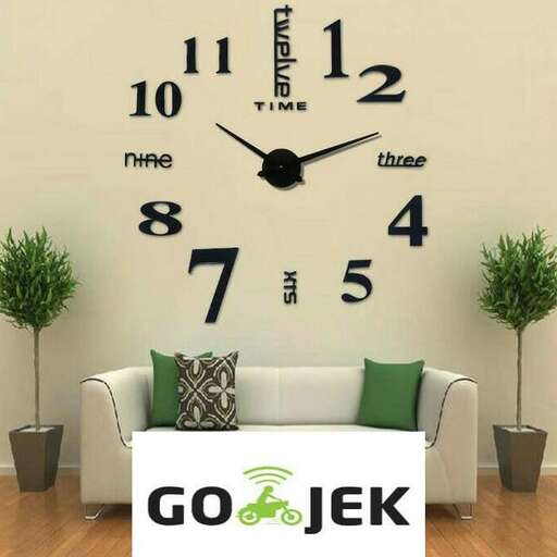 a living room with a white couch and a clock.