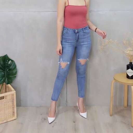 a woman in a pink tank top and jeans.