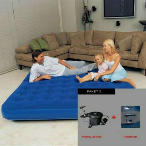 a family laying on a mattress in a living room.