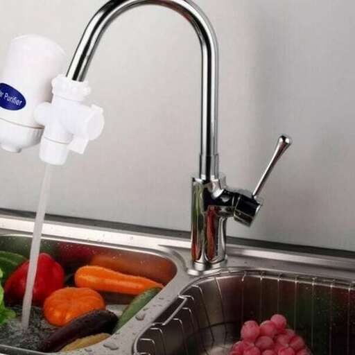 a sink with a faucet and vegetables in it.