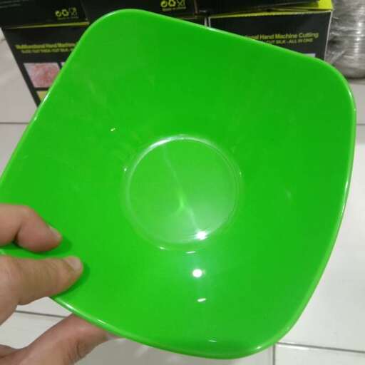 a green plate with a hole in it