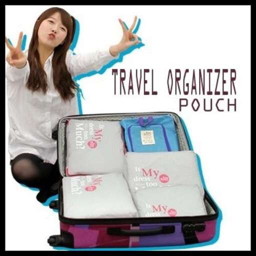a woman sitting in a suitcase with several bags in front of her.