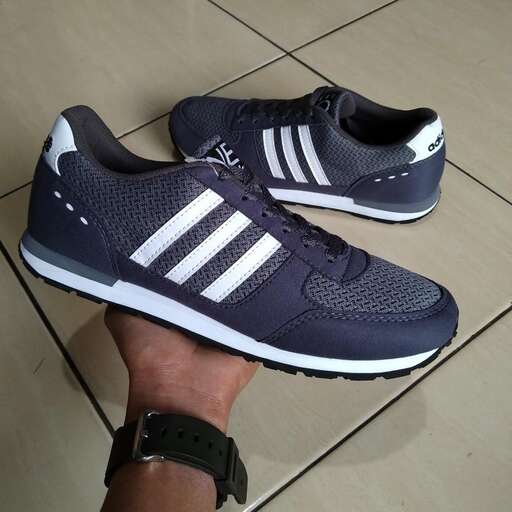 a person's hand holding a pair of shoes.