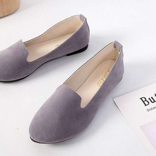 a pair of grey shoes with a book next to it.