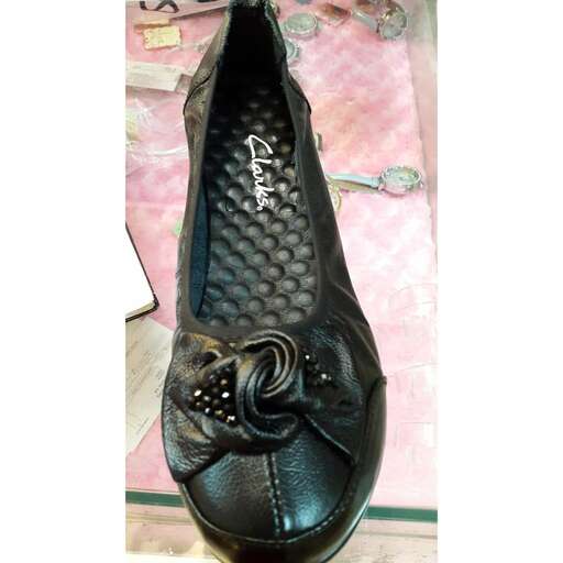 a pair of black leather shoes with a floral pattern on the sole.