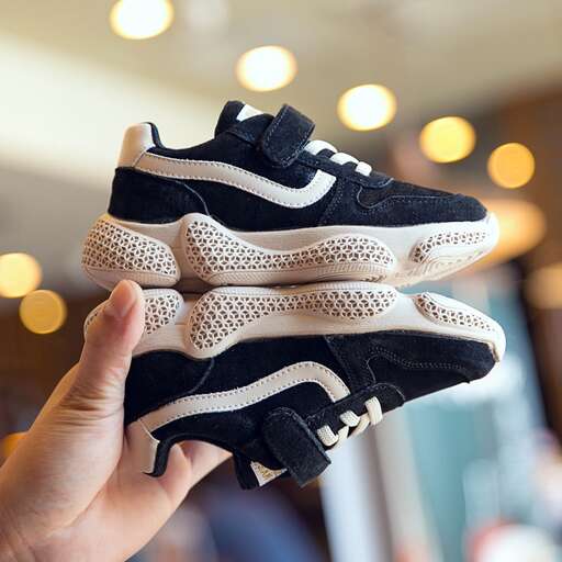 a hand holding a pair of shoes