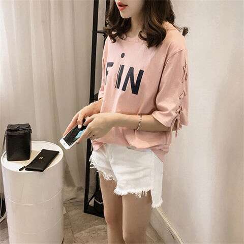 a woman in a pink sweater holding a pair of scissors.