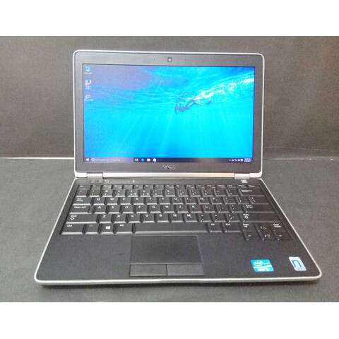 a laptop computer sitting on a table with a blue screen.