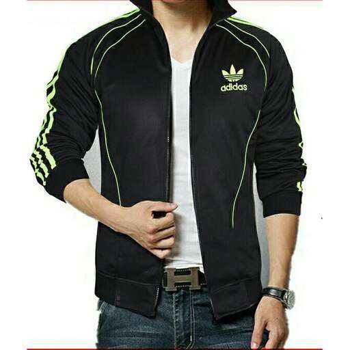 a man in a white shirt with a green logo on the front and a white t - shirt underneath.