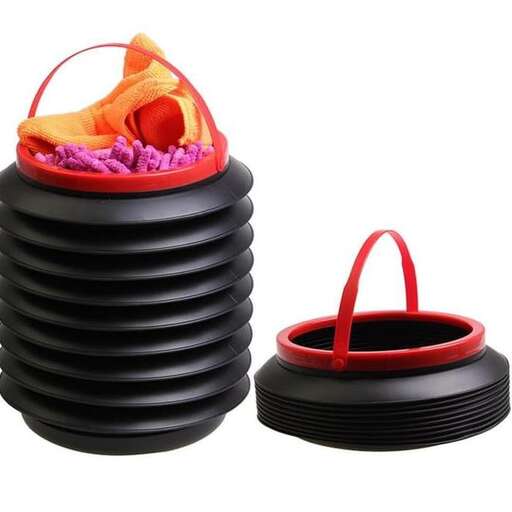 a black plastic bucket with a red handle and a red plastic bag.