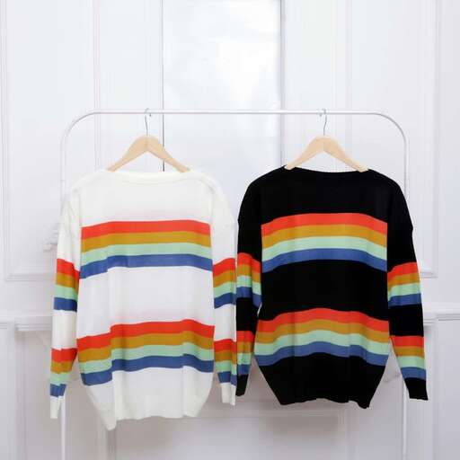 rainbow striped sweaters on a hanger