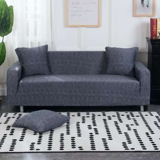 a modern living room with a white rug and gray sofa.