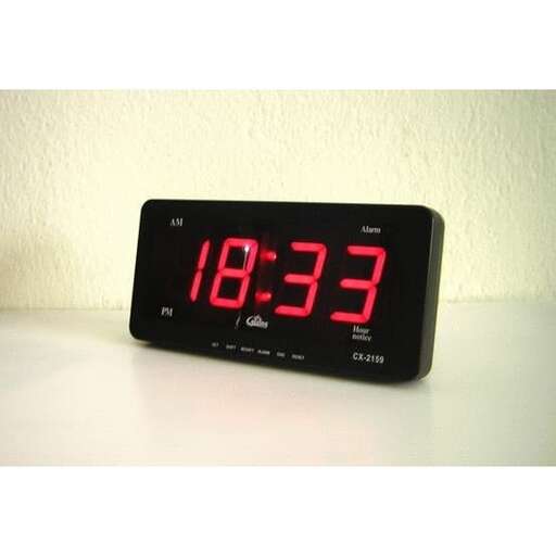 a clock with the time lit up on a table.