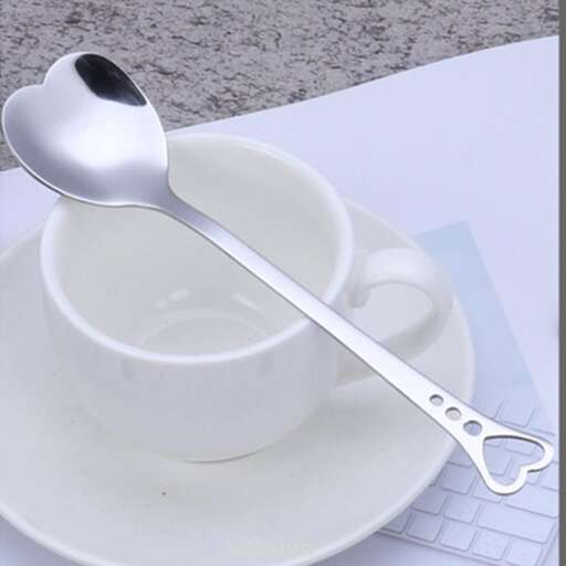 a spoon is sitting on a saucer and a cup of coffee.