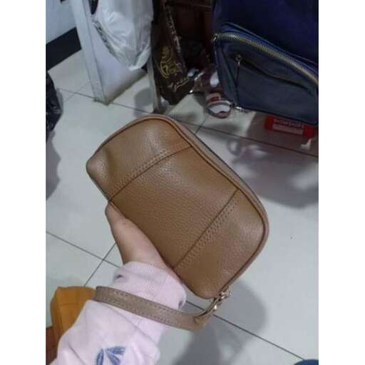 a person holding a suitcase with a hand holding it.