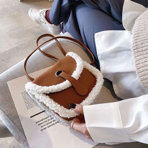 a woman holding a purse and a book.