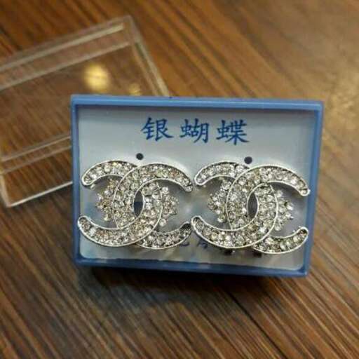 a pair of earrings with a square box.